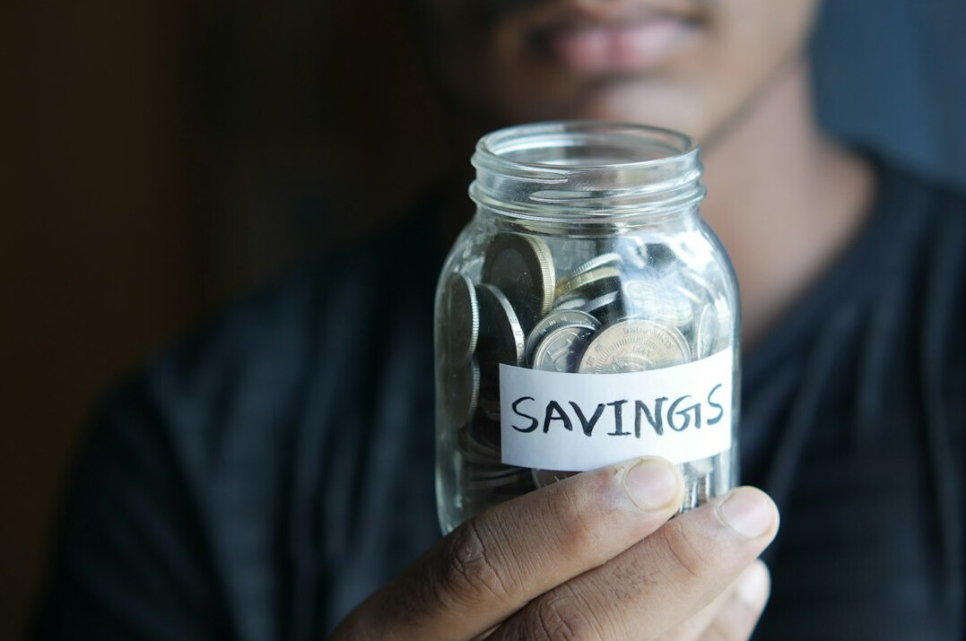 person saving money in jar